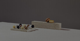 Freiburg Präsentation von Pralinen und Macarons auf einer Steinplatte und einem Block.